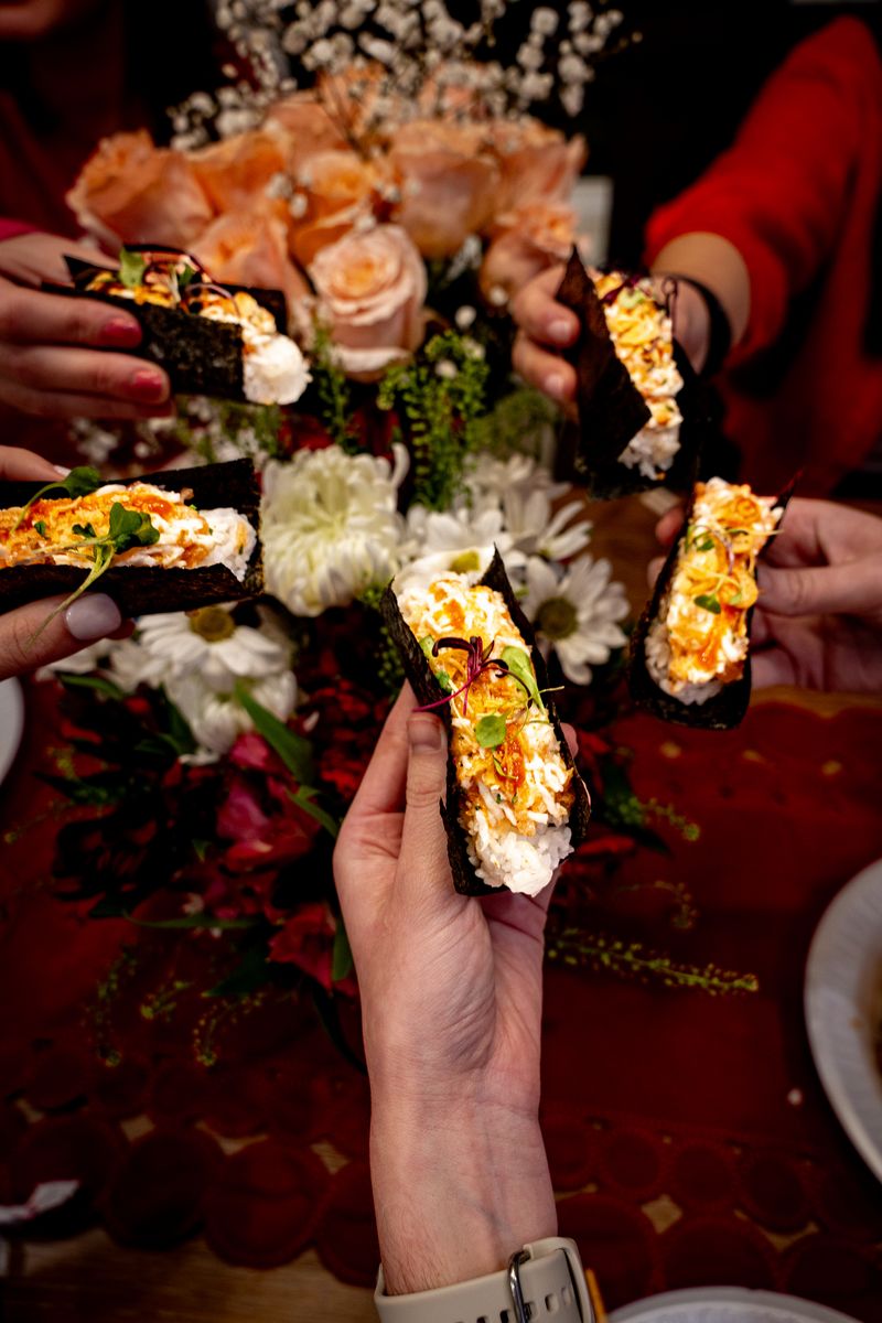 Guests toasting with hand rolls.
